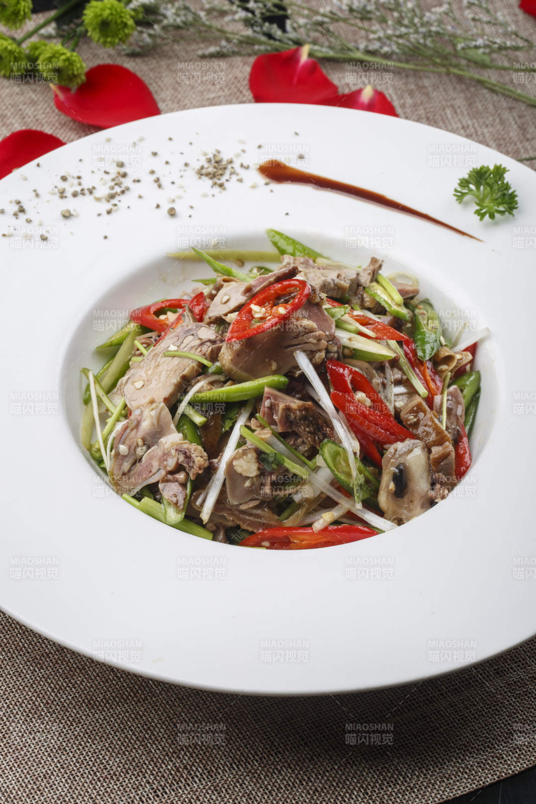 白色圆形瓷盘装的凉拌辣牛舌图片