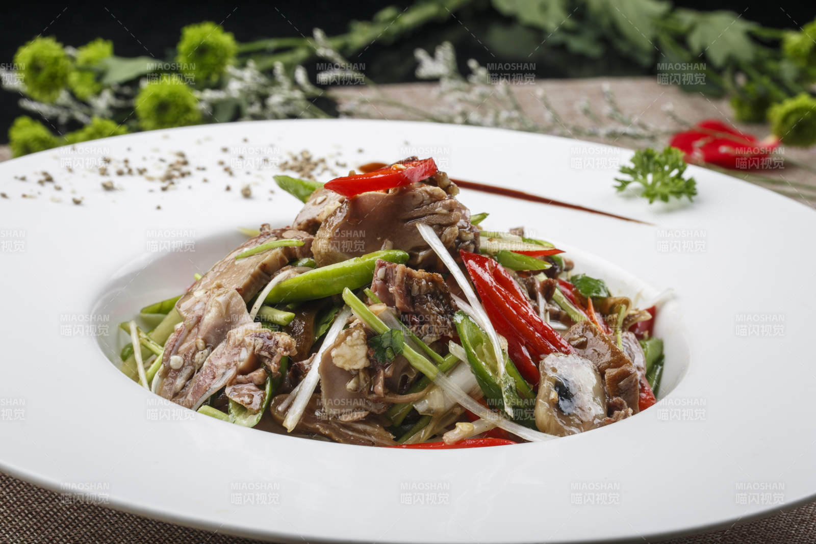 白色圆形瓷盘装的凉拌辣牛舌图片