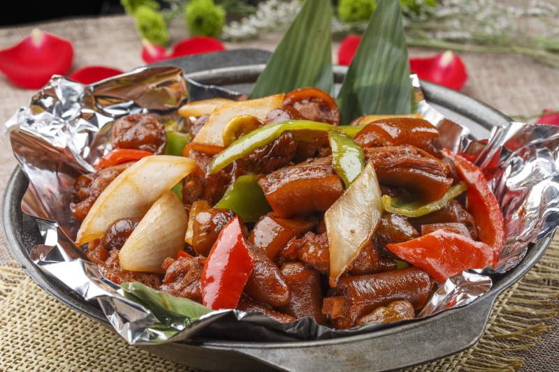 黑色砂锅装的锡纸砂锅煨猪尾图片