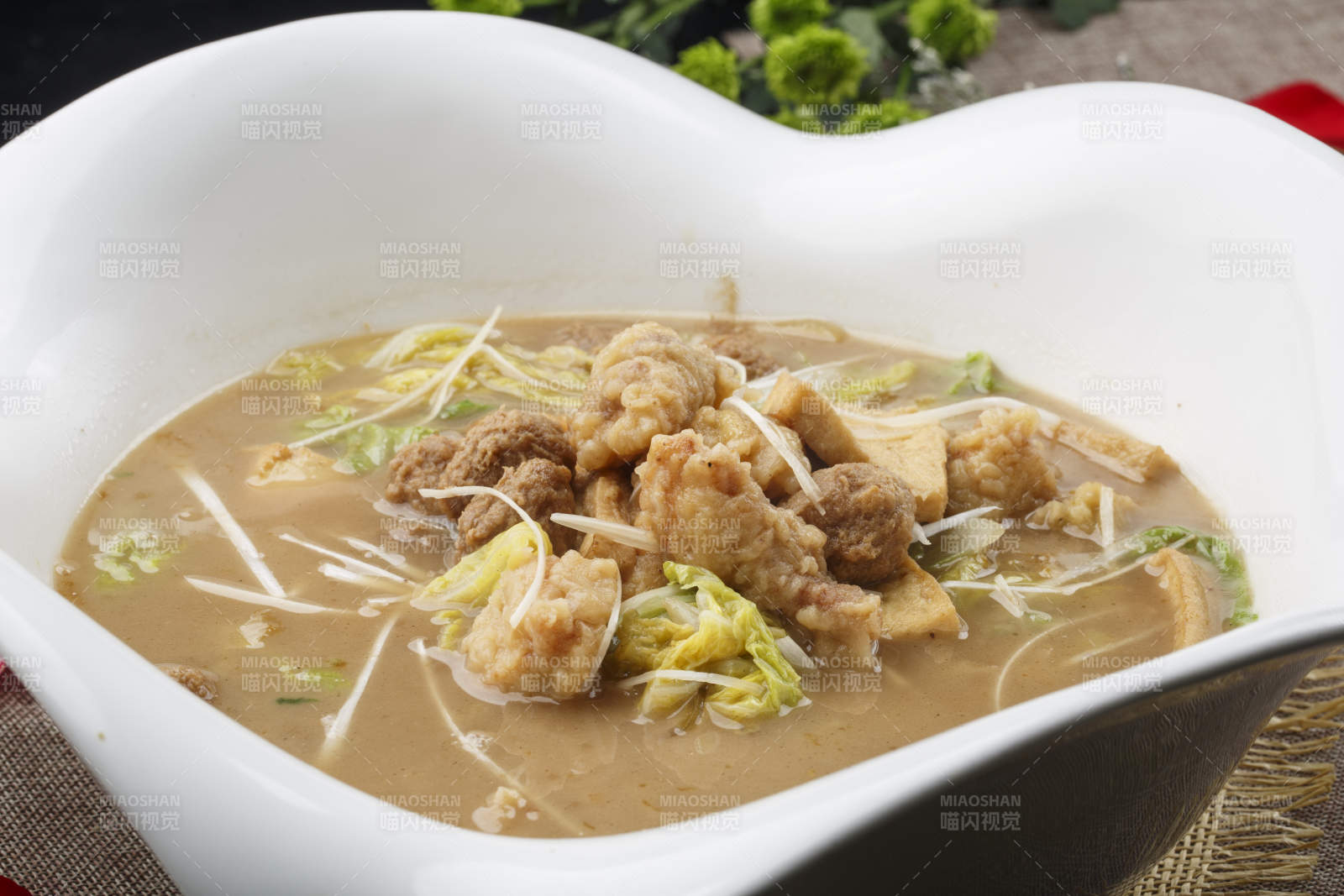 心形白色瓷汤盆装的酥肉卤豆泡图片