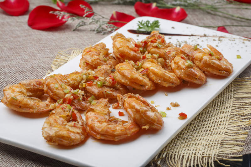 白色椭圆瓷盘装的蒜蓉油炸开背大明虾图片