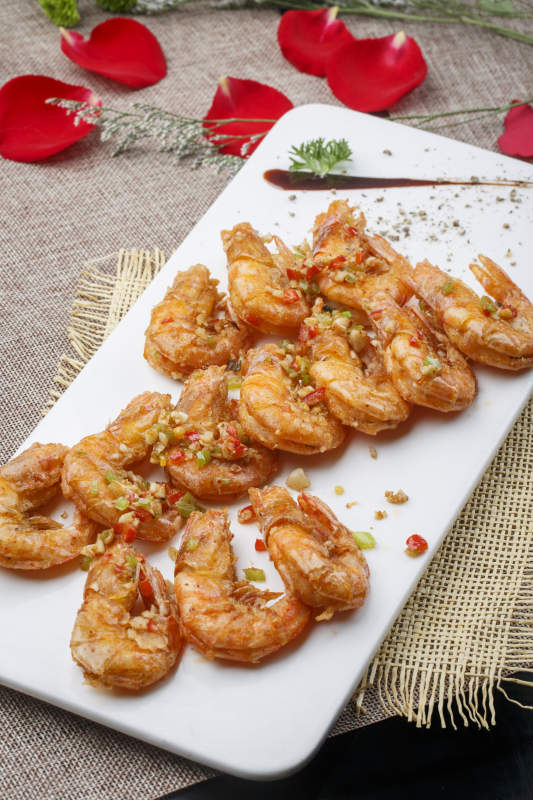 白色椭圆瓷盘装的蒜蓉油炸开背大明虾图片