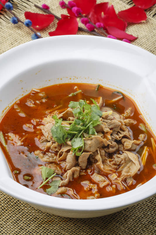 白色瓷汤盆装的香辣肥牛煮海肠图片