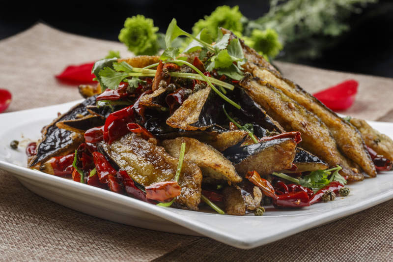 白色方瓷盘装的香辣风味油炸茄子图片