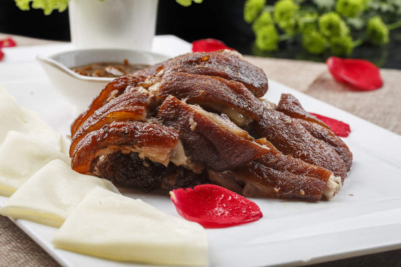 白色瓷盘装的薄饼酱肘子图片