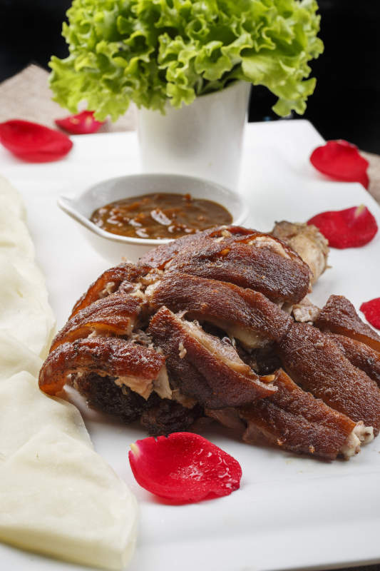 白色瓷盘装的薄饼酱肘子图片