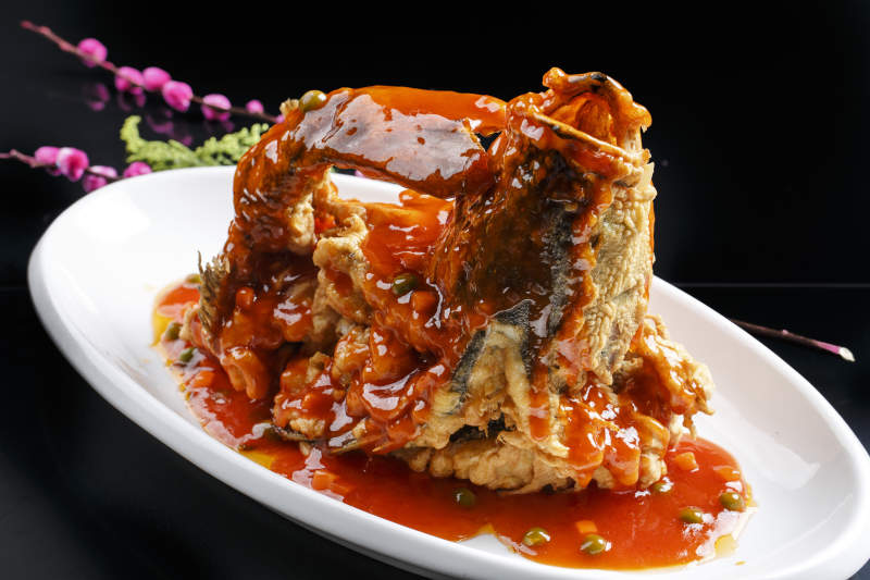 黑色瓷盘装的金米避风塘炸虾图片