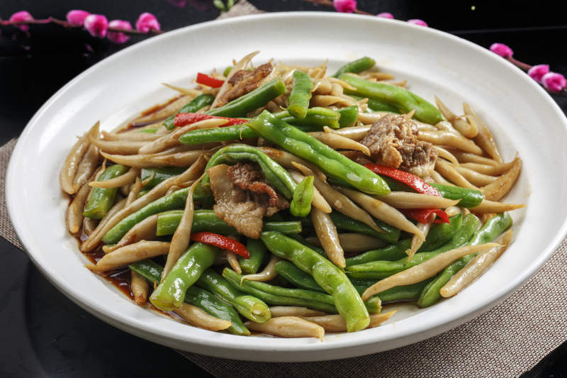 白色瓷盘装的五花肉片豆角焖生下鱼图片