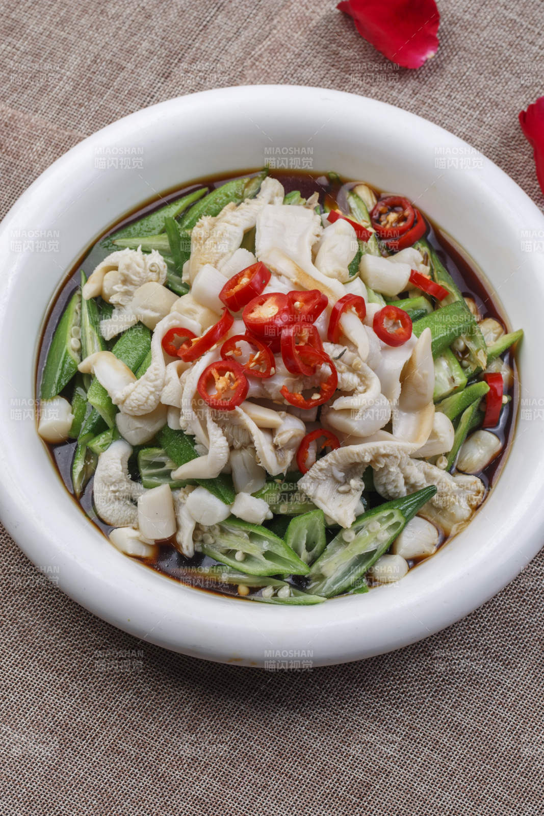 白色圆瓷盘装的秋葵带子肉图片