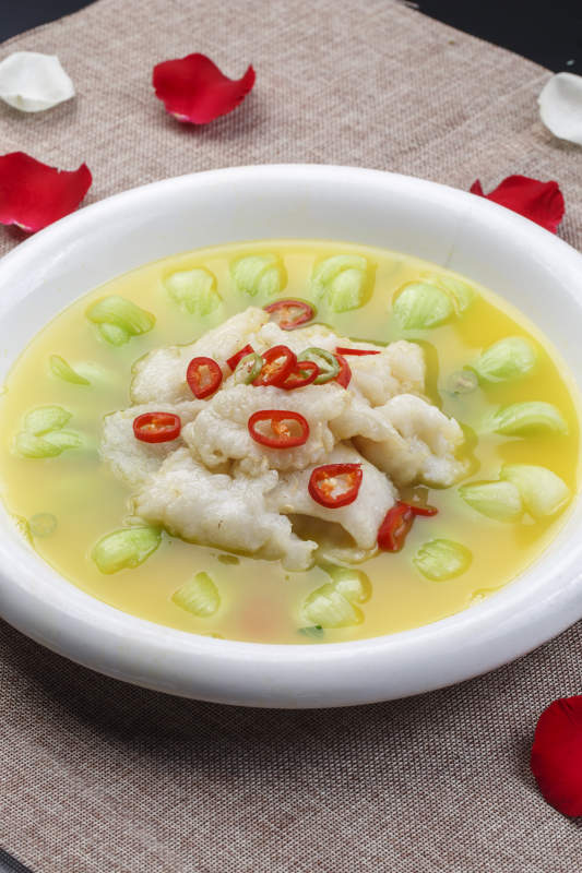 白色圆瓷盘装的酸汤龙利鱼图片