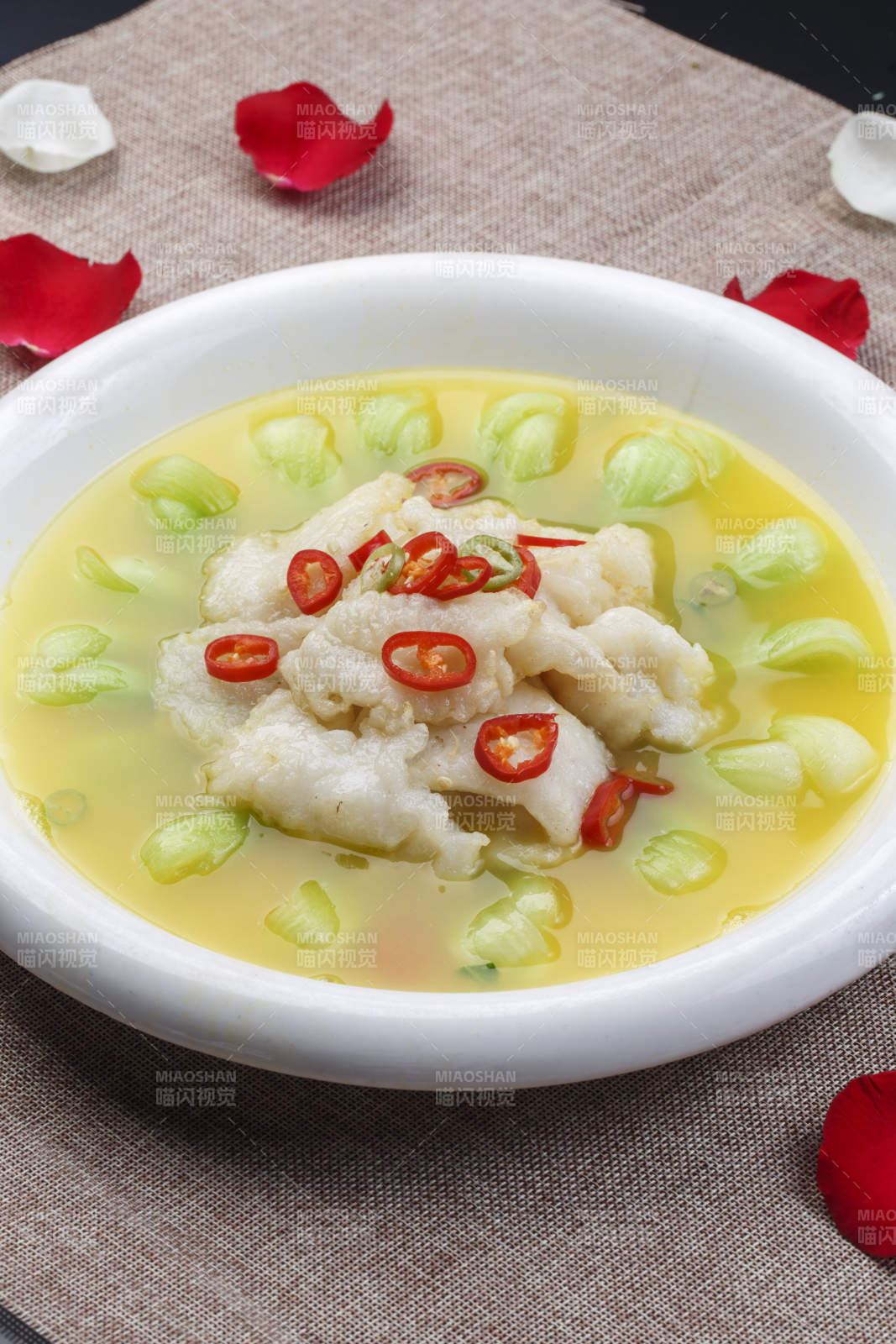 白色圆瓷盘装的酸汤龙利鱼图片