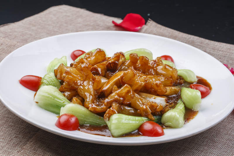 白色圆瓷盘装的葱烧海参蹄筋图片