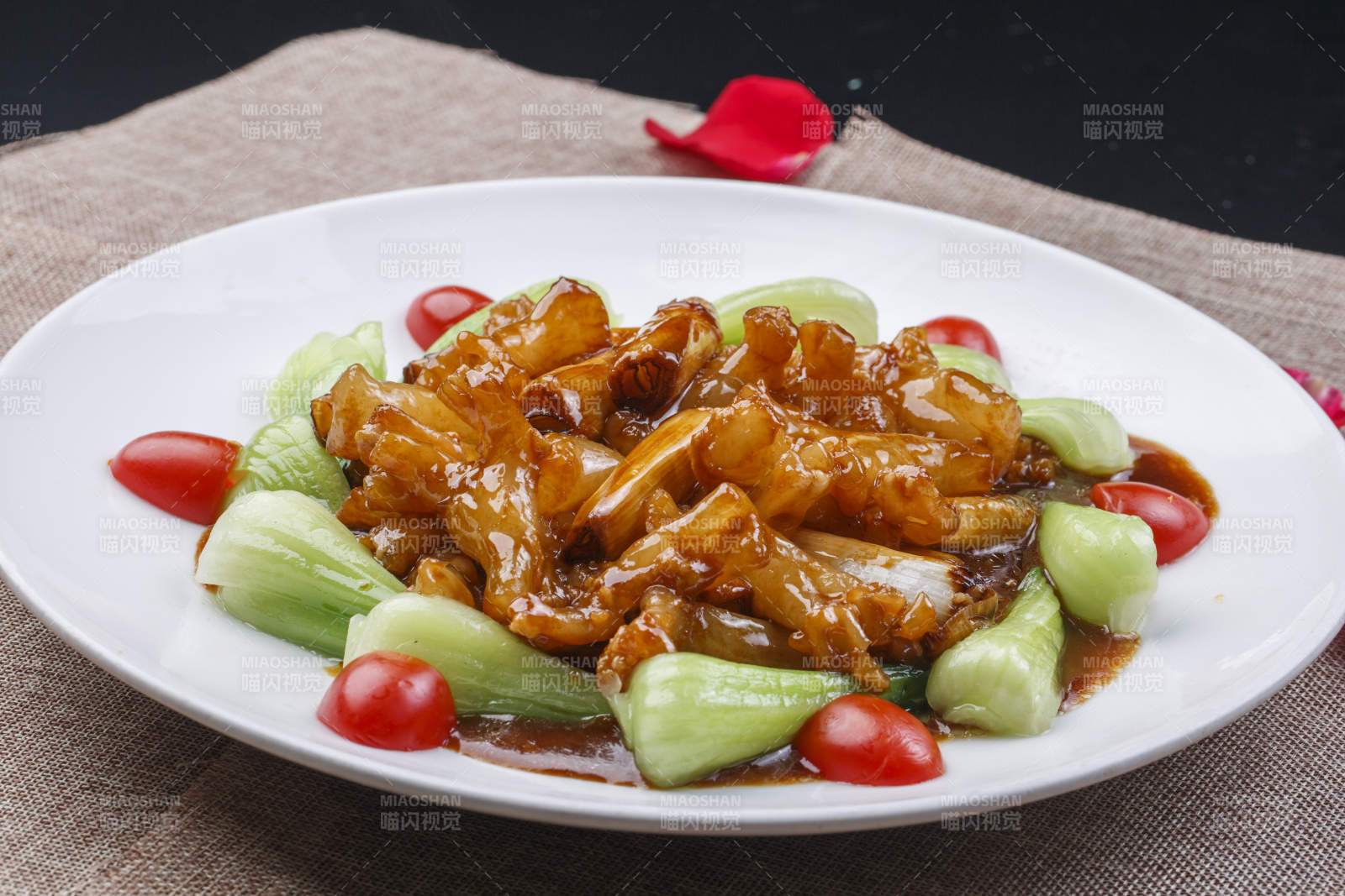 白色圆瓷盘装的葱烧海参蹄筋图片