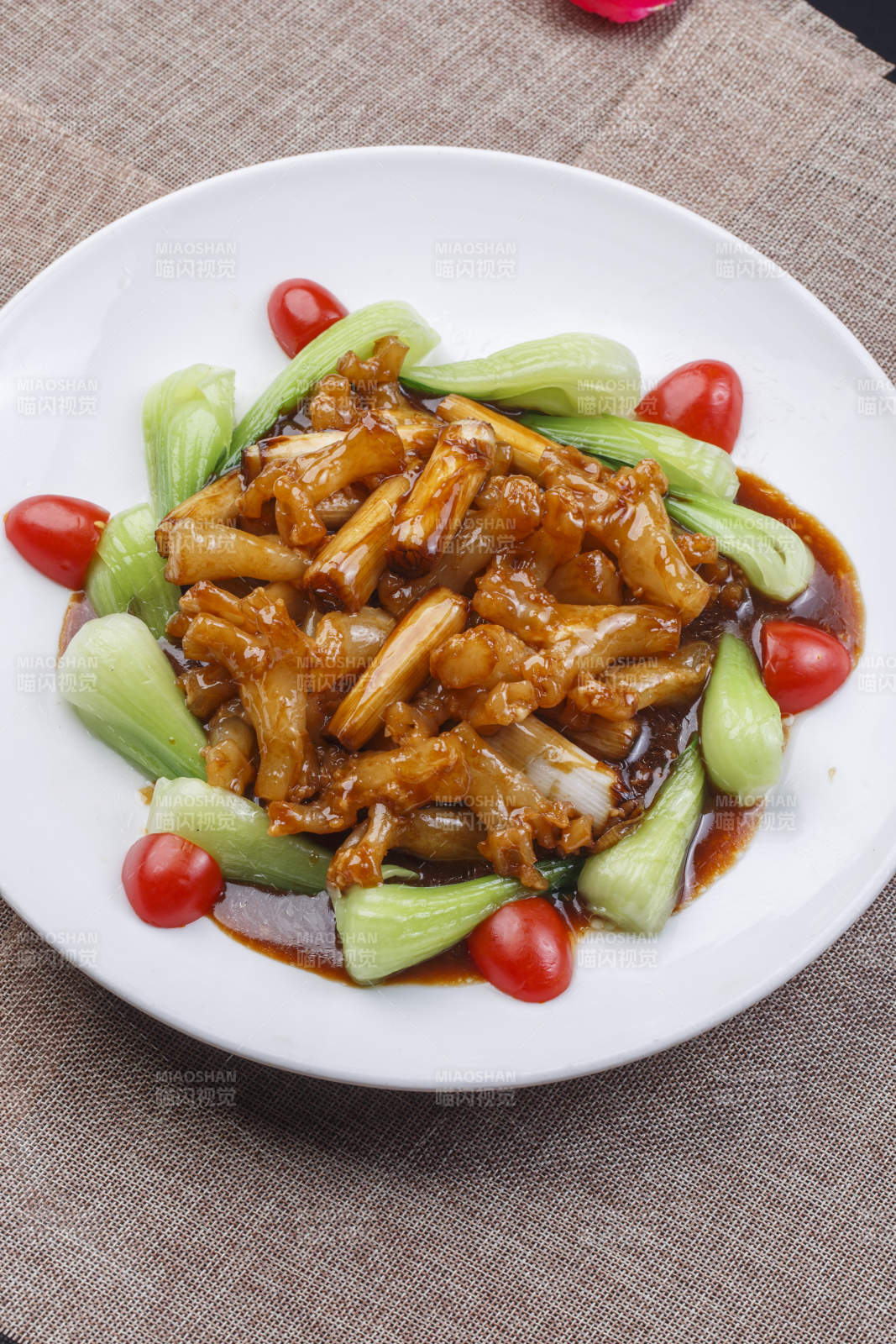 白色圆瓷盘装的葱烧海参蹄筋图片