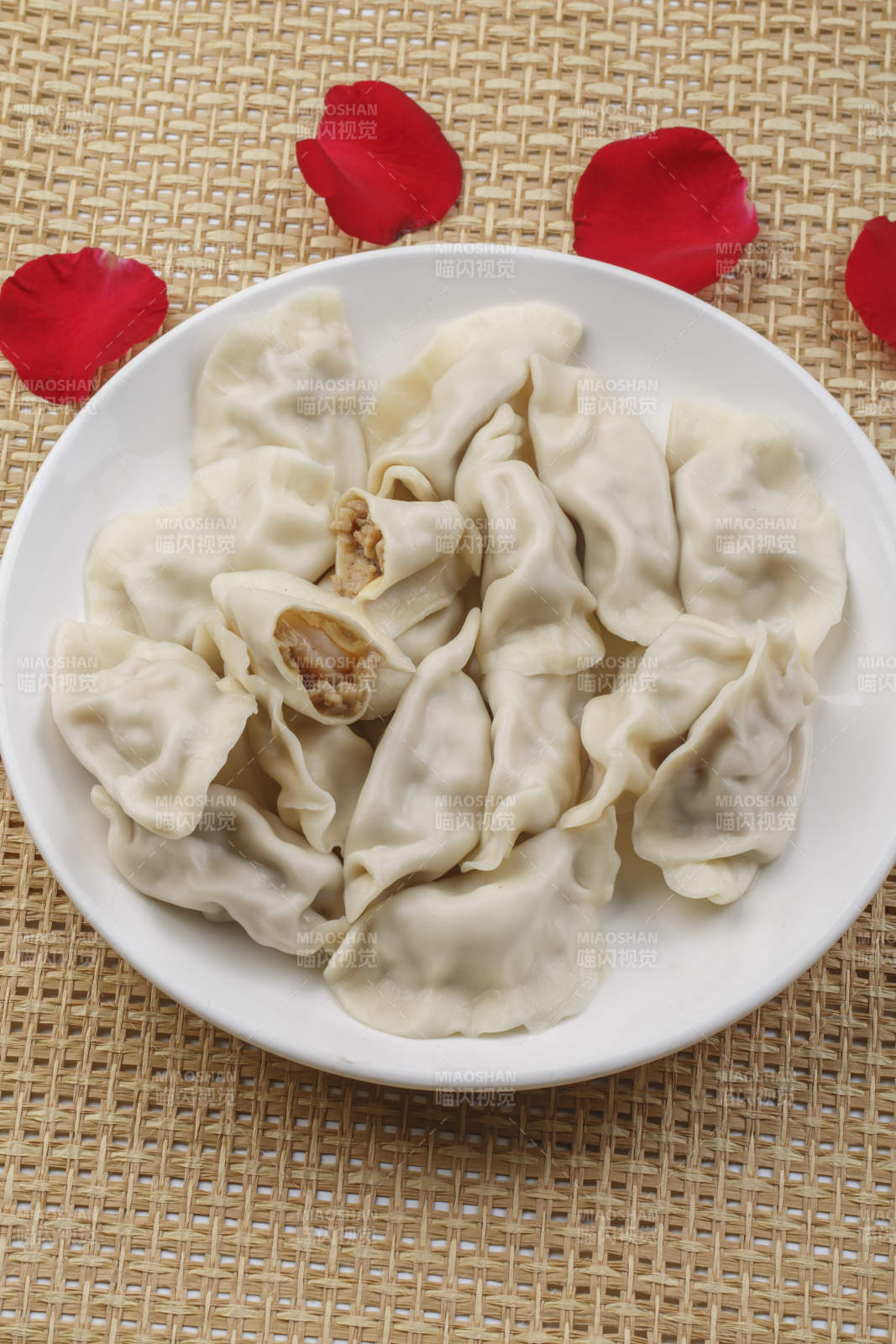 白色瓷盘装的现出锅的海鲜饺子图片