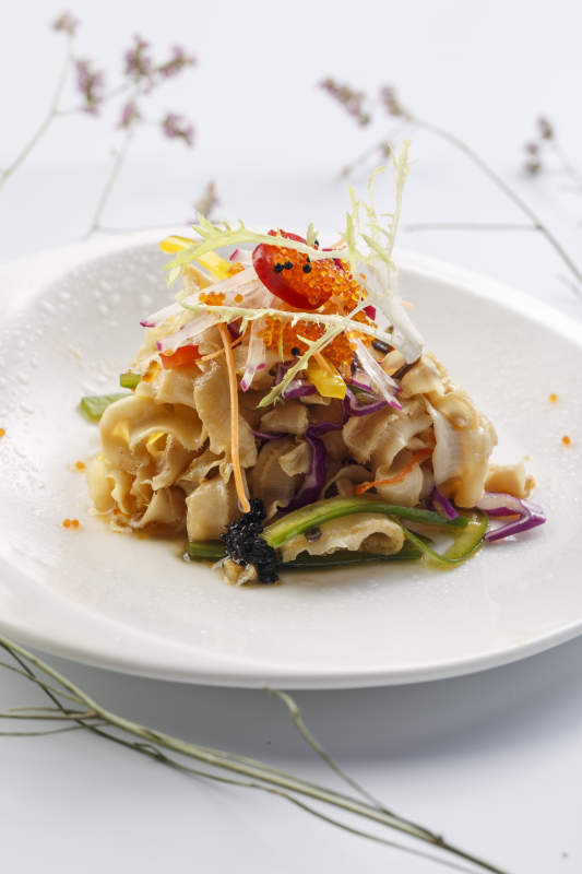 白色瓷盘装的铁板麻辣扇贝裙边图片