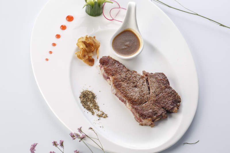 白色瓷盘装的安格斯西冷牛排图片