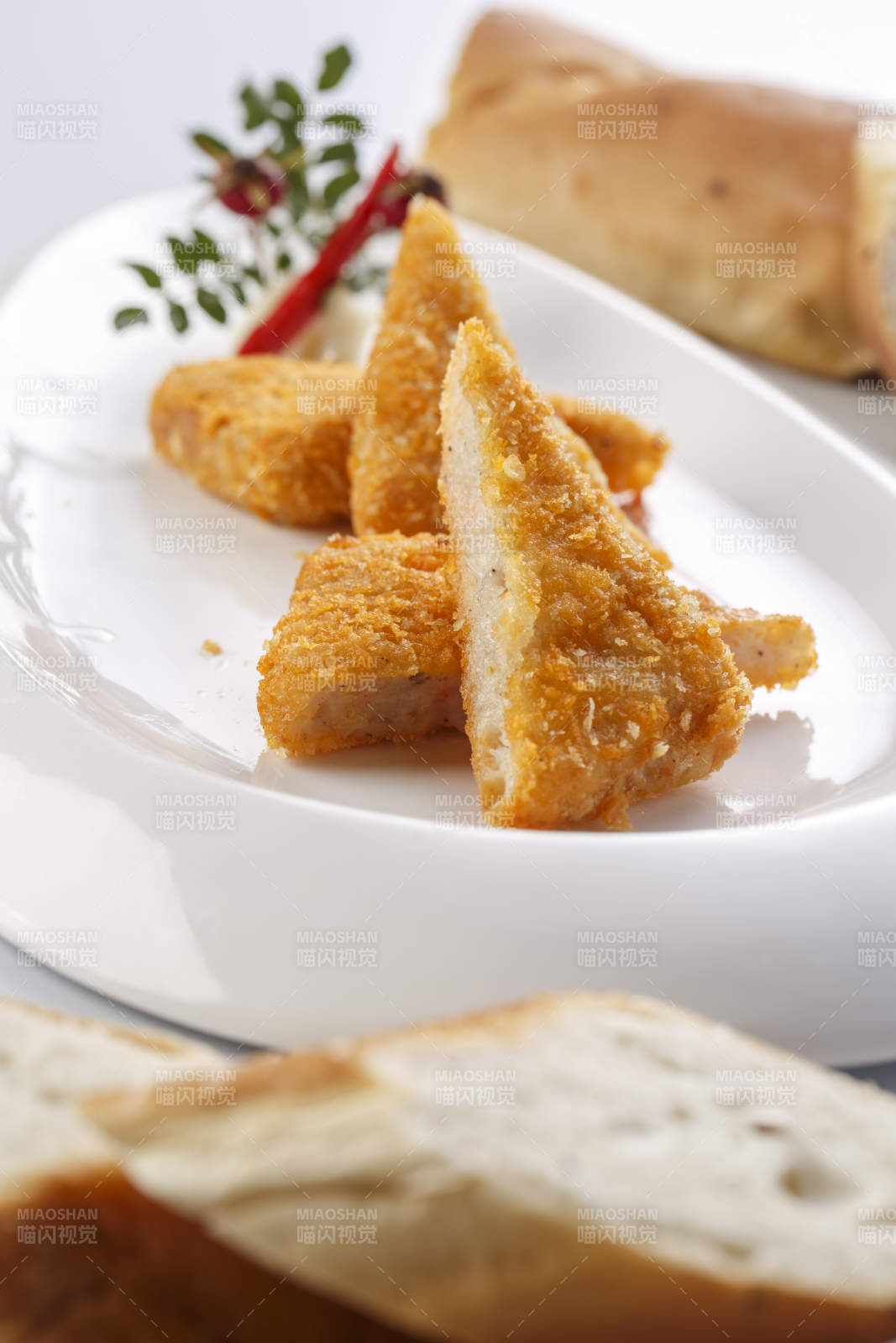 白色瓷盘装的油炸鲜虾饼切块图片