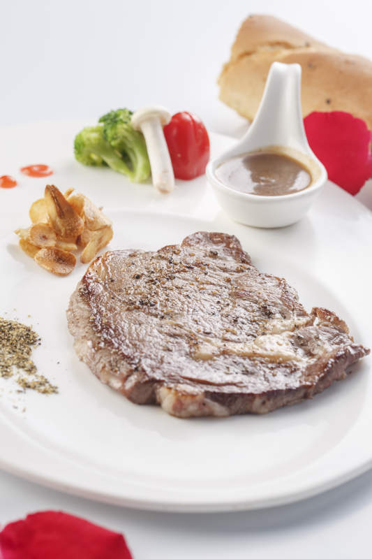 白色瓷盘装的安格斯西冷牛排图片