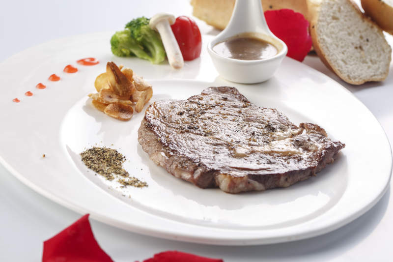 白色瓷盘装的安格斯西冷牛排图片