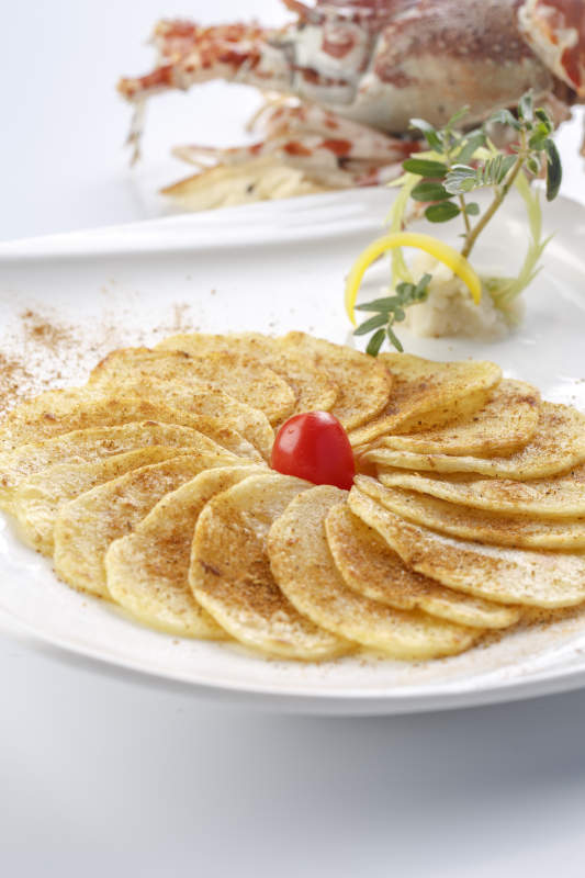 白色瓷盘装的铁板香煎土豆片图片