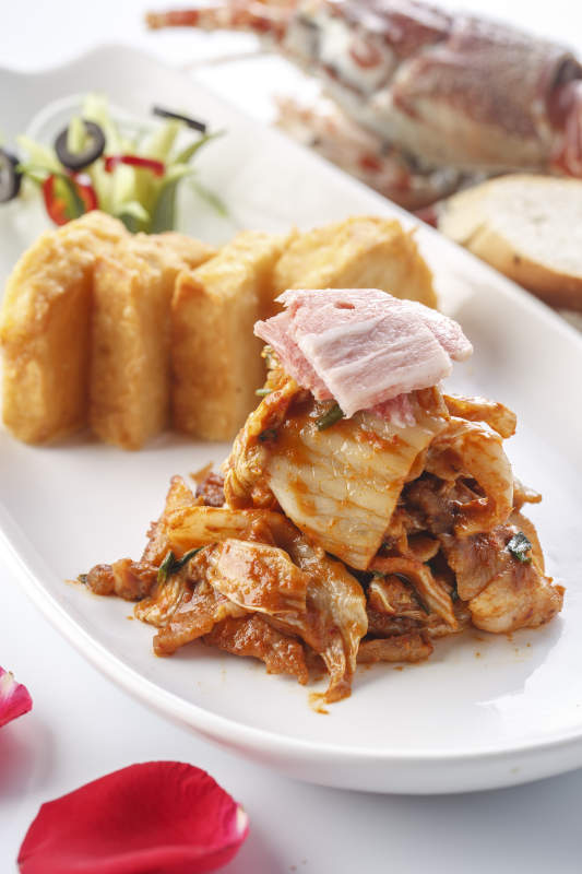 精美餐具装的铁板辣白菜炒五花肉配炸馒头片图片