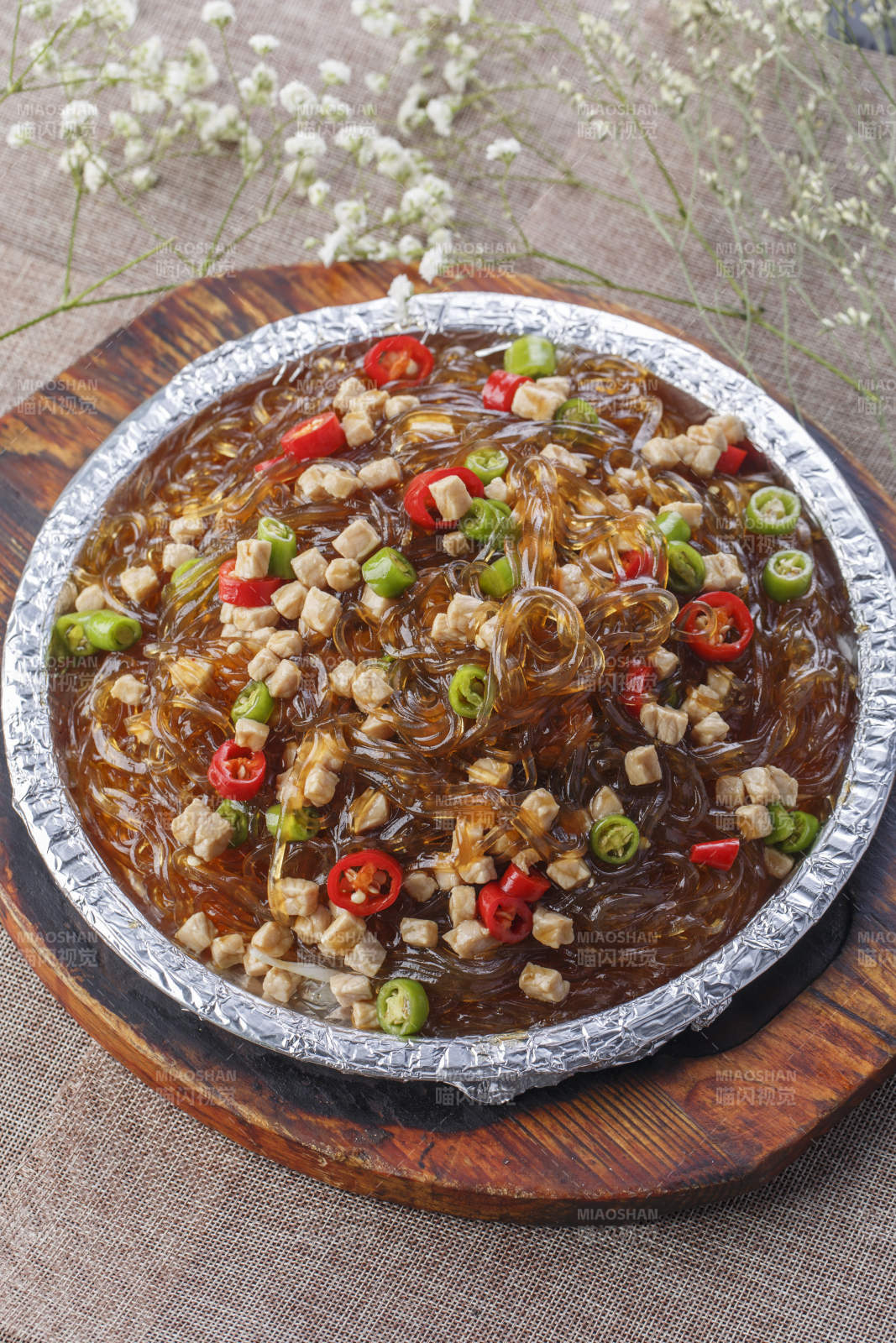 木托板上的锡纸铁板装的香辣鸡丁水晶粉图片