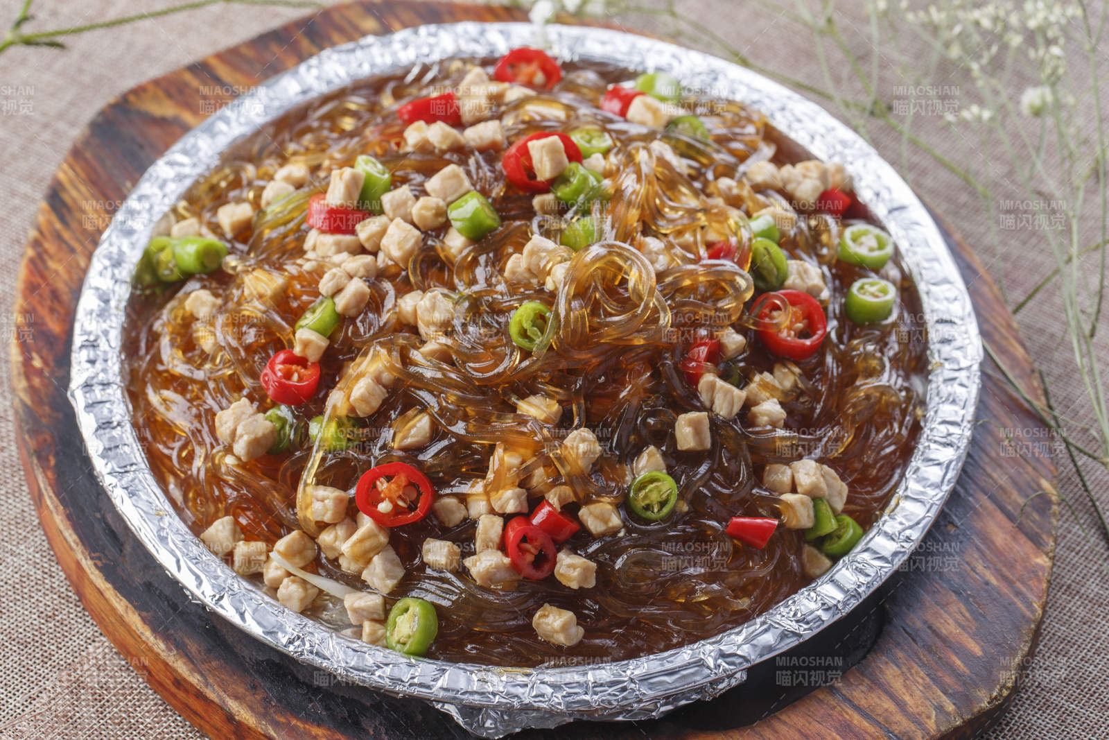 木托板上的锡纸铁板装的香辣鸡丁水晶粉图片