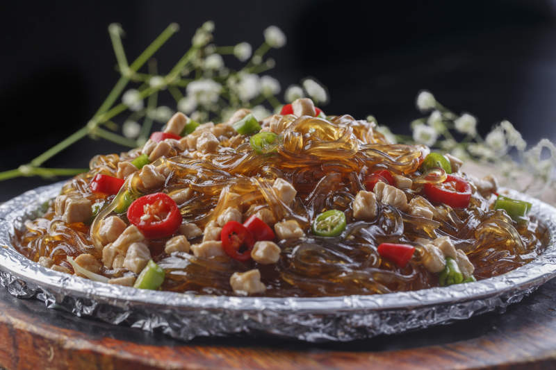 木托板上的锡纸铁板装的香辣鸡丁水晶粉图片