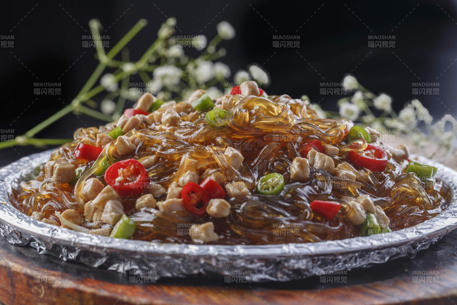 木托板上的锡纸铁板装的香辣鸡丁水晶粉图片