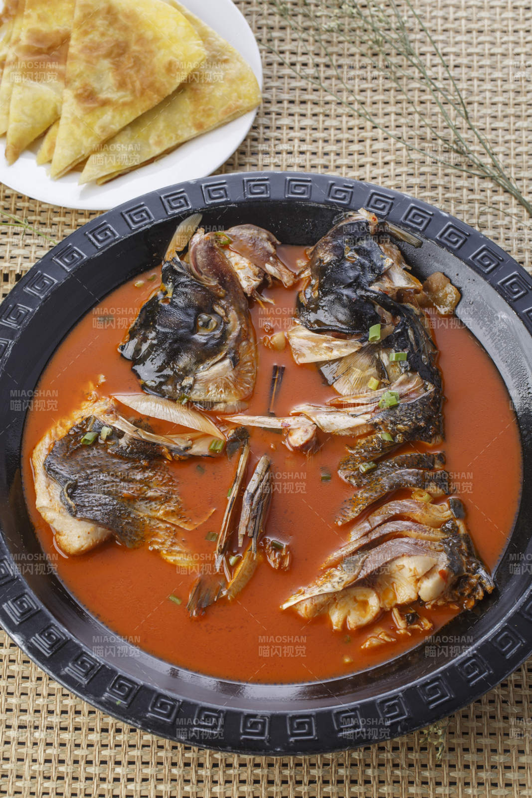 黑色铁盘装的浓汤鱼头泡大饼图片