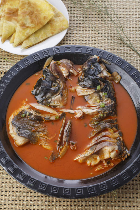 黑色铁盘装的浓汤鱼头泡大饼图片