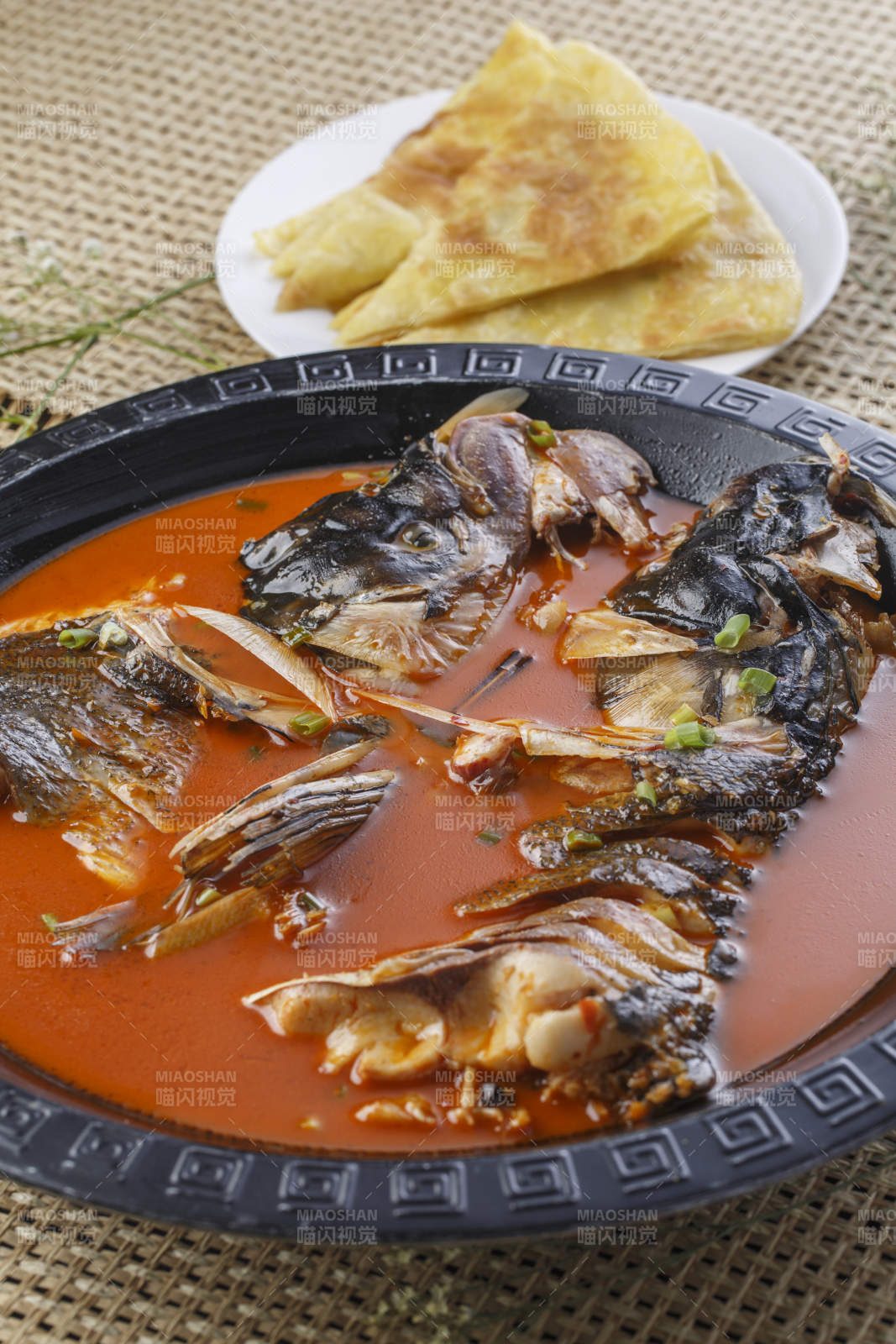 黑色铁盘装的浓汤鱼头泡大饼图片