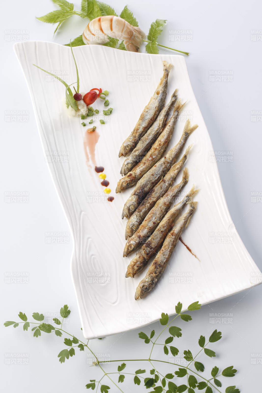 精美餐具装的法式铁板椒盐多春鱼图片