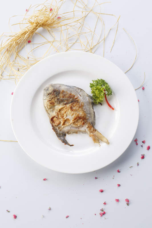 白色瓷盘装的法式铁板银鲳鱼图片