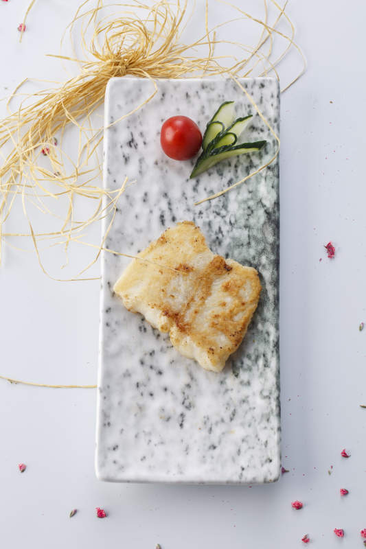 精美餐具装的法式铁板椒盐石板鱼块图片