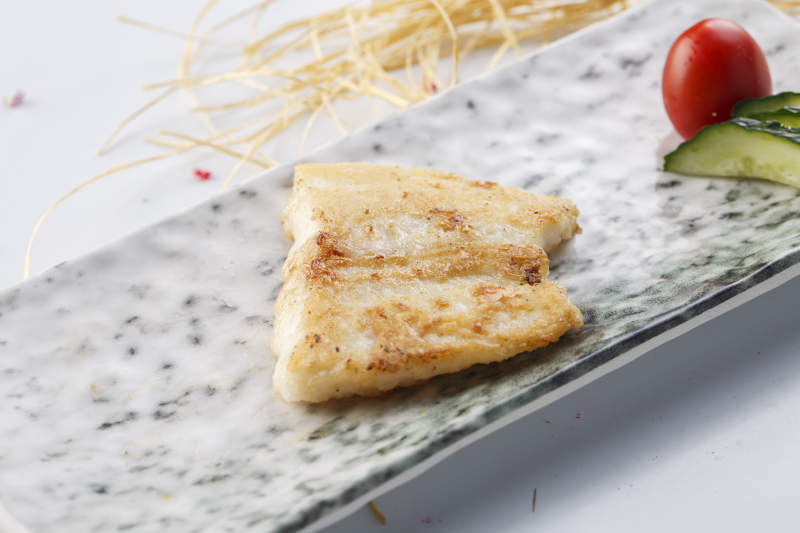 精美餐具装的法式铁板椒盐石板鱼块图片