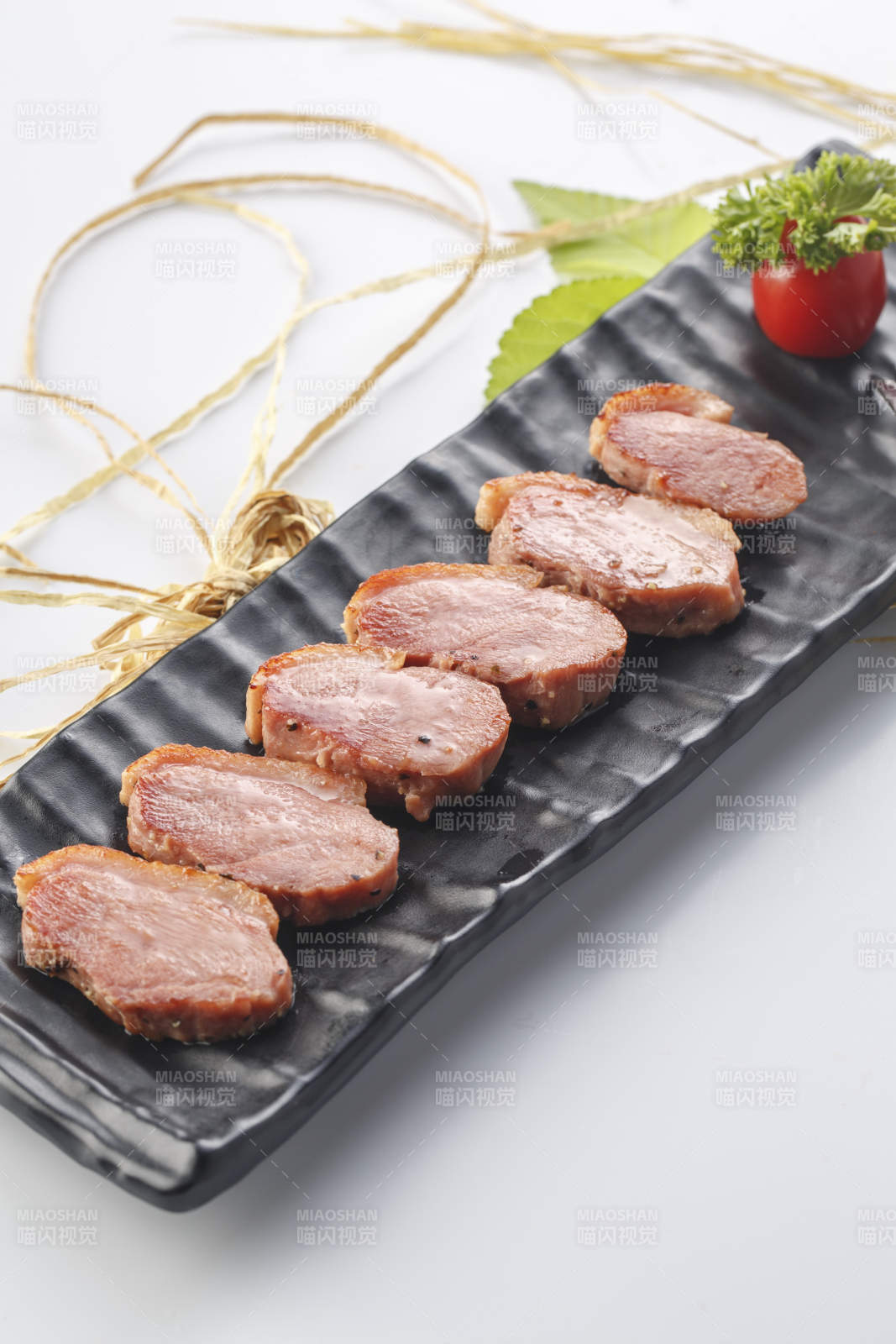 白色瓷盘装的烟熏鸭胸肉切片图片