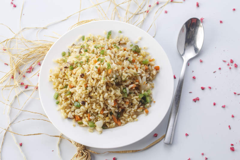 铁板虾干蛋炒饭摆放在草垫上图片