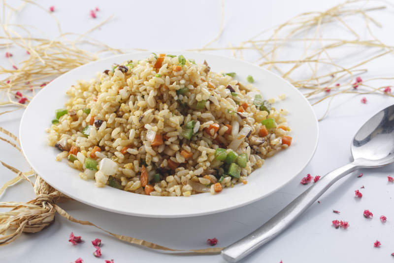 铁板虾干蛋炒饭摆放在草垫上图片