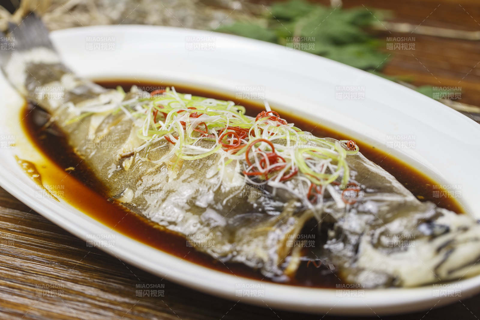 椭圆形白瓷盘装的清蒸偏口鱼左口鱼图片