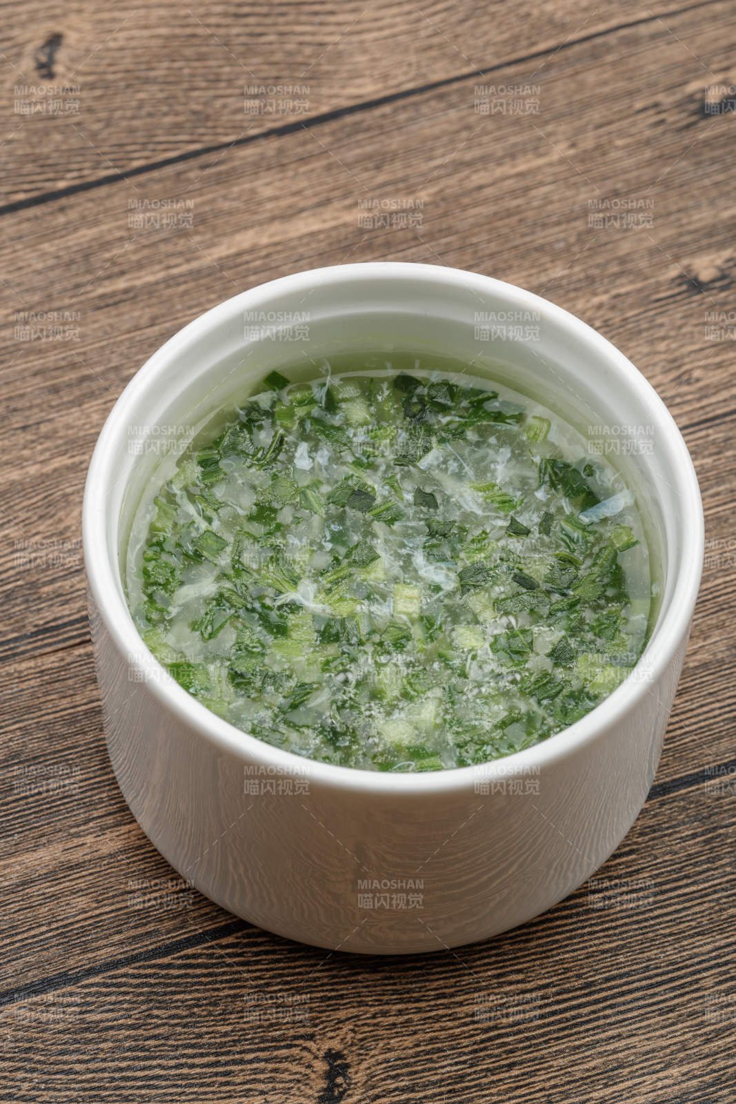 白色瓷汤盅装的韭香蛋花汤图片