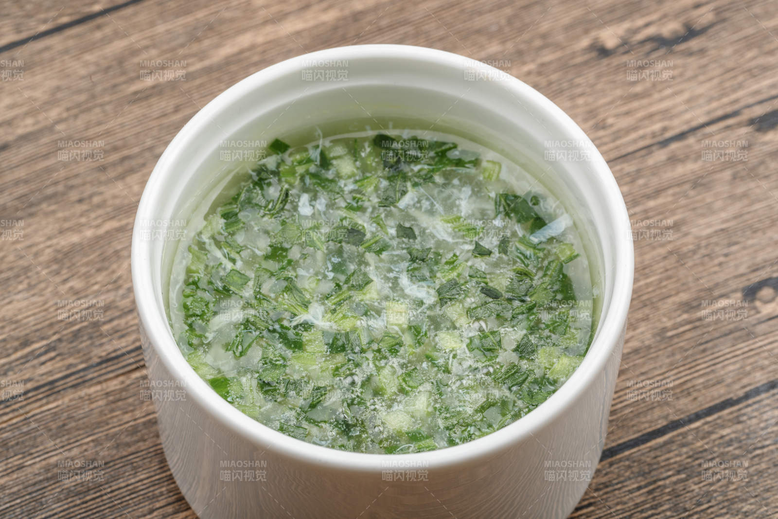 白色瓷汤盅装的韭香蛋花汤图片