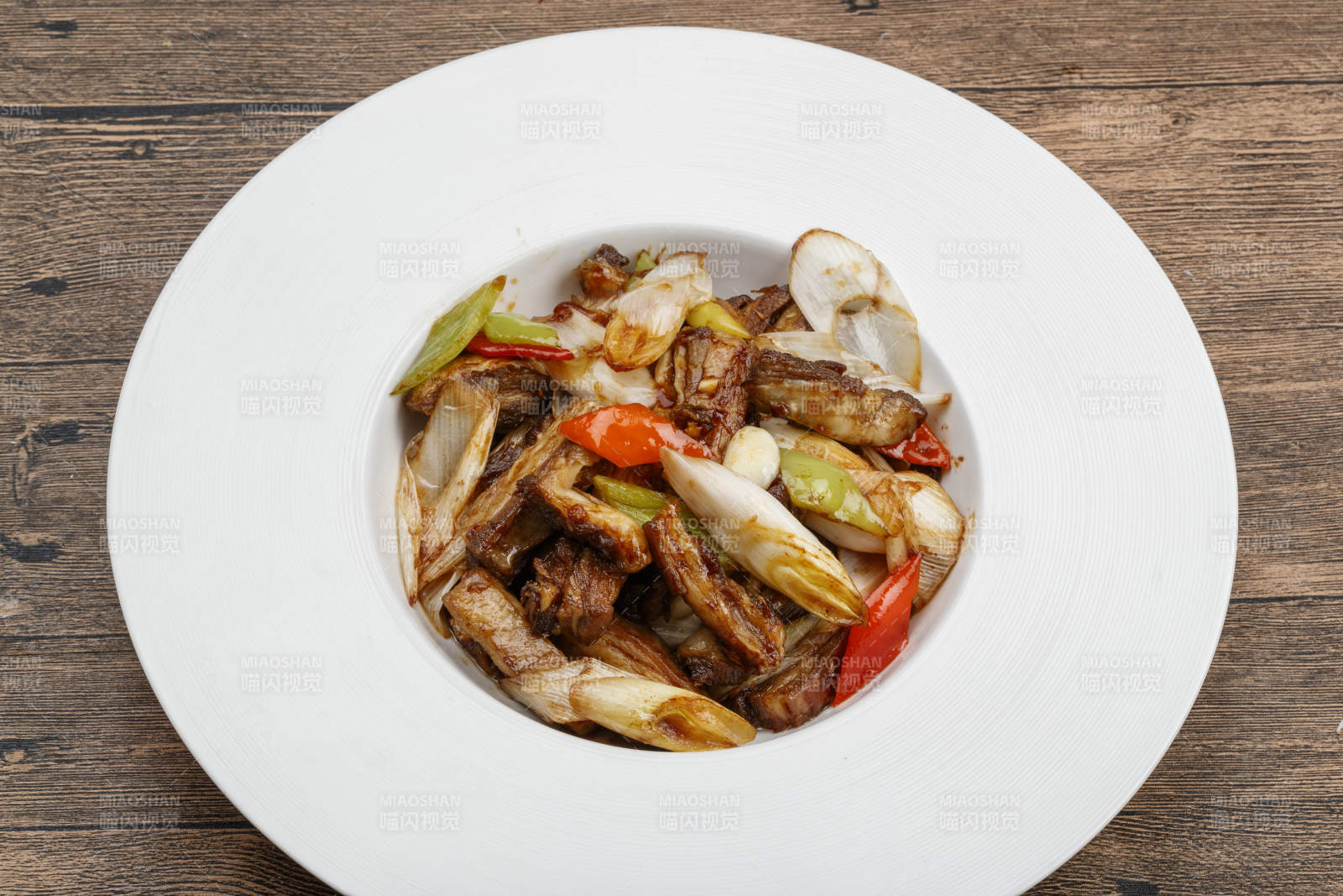 白色瓷盘装的葱爆羊五花肉图片