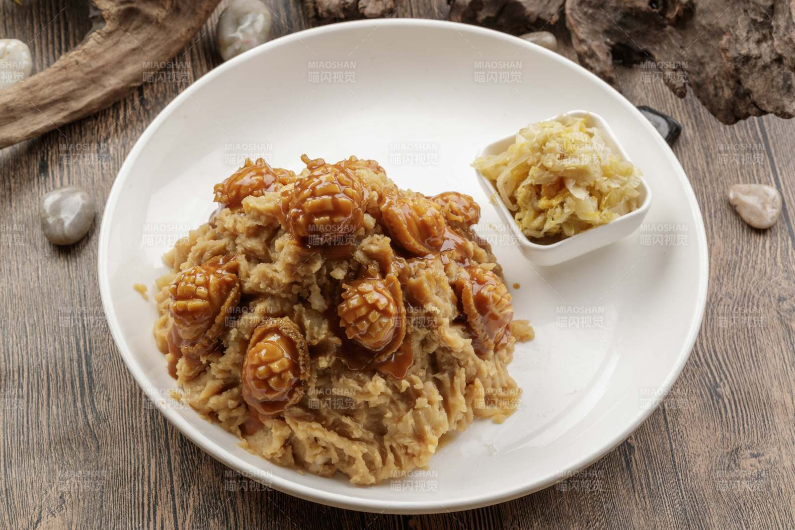 白色圆盘装的土豆焖鲍鱼摆放在樟木砧板上图片