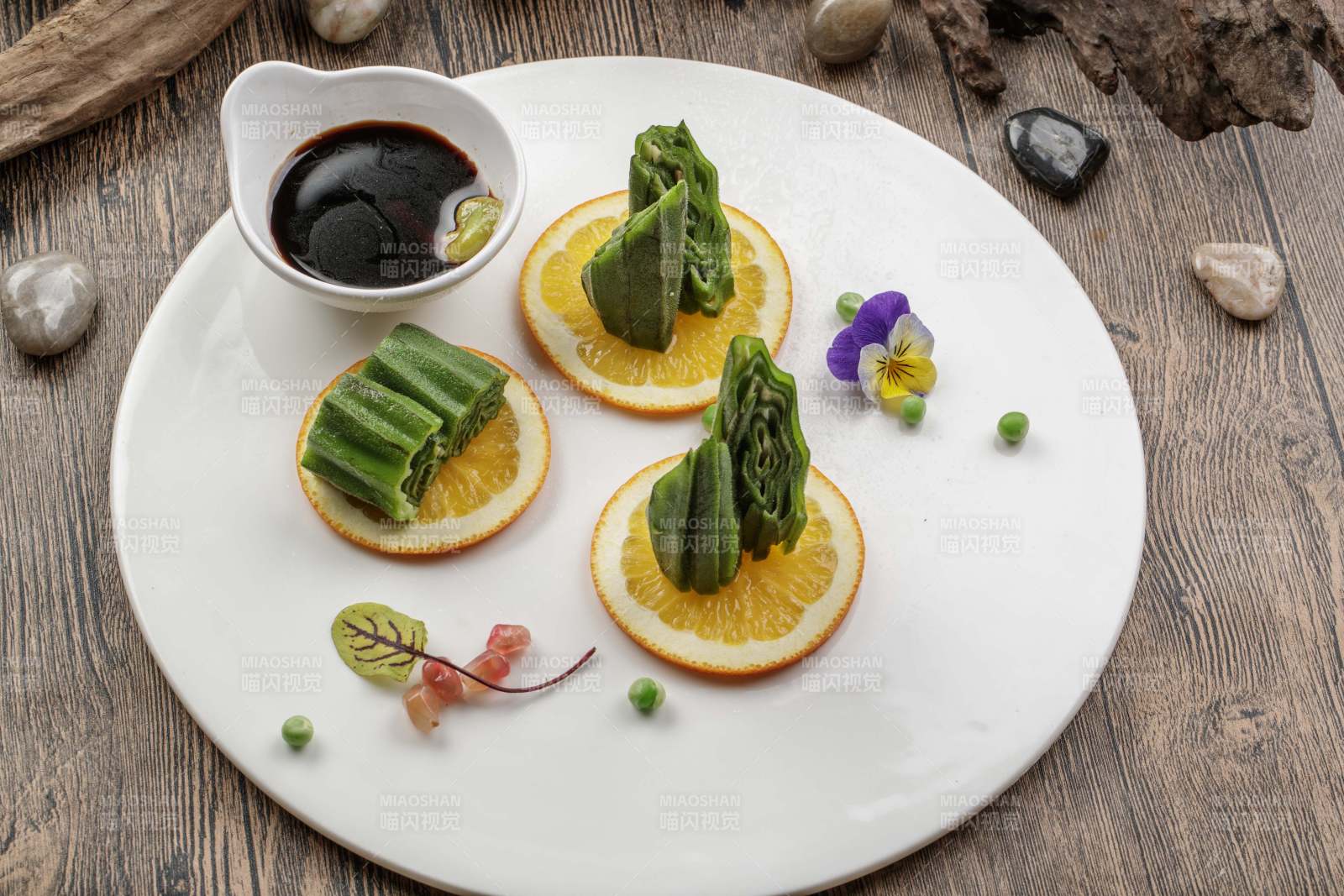 瓷盘装的甜橙凉拌秋葵图片