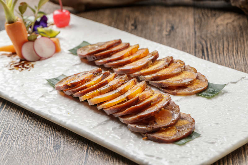 白色瓷盘装的猪耳鱿鱼蛋黄卷图片