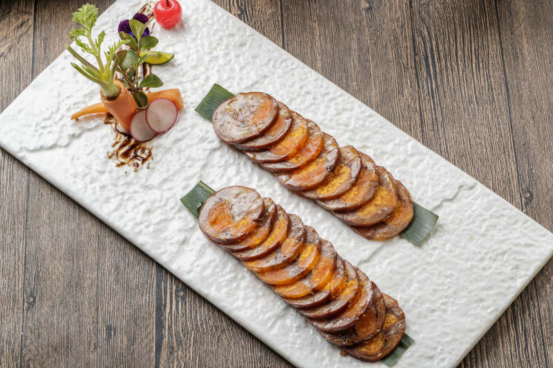 白色瓷盘装的猪耳鱿鱼蛋黄卷图片