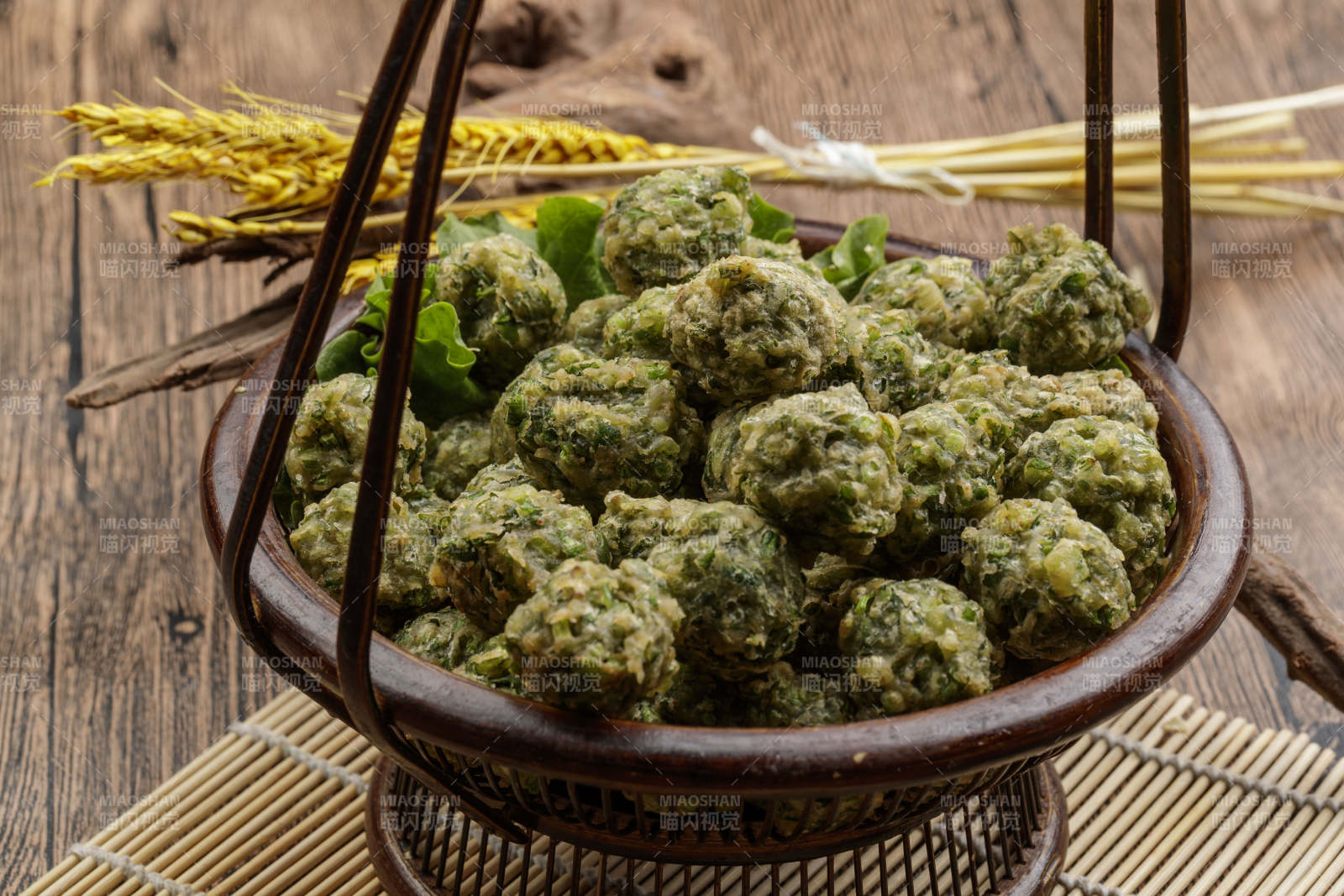 棕色竹篮装的飘香油炸野菜丸子图片