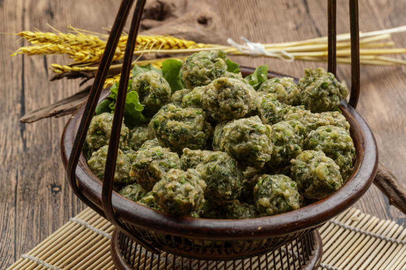 棕色竹篮装的飘香油炸野菜丸子图片